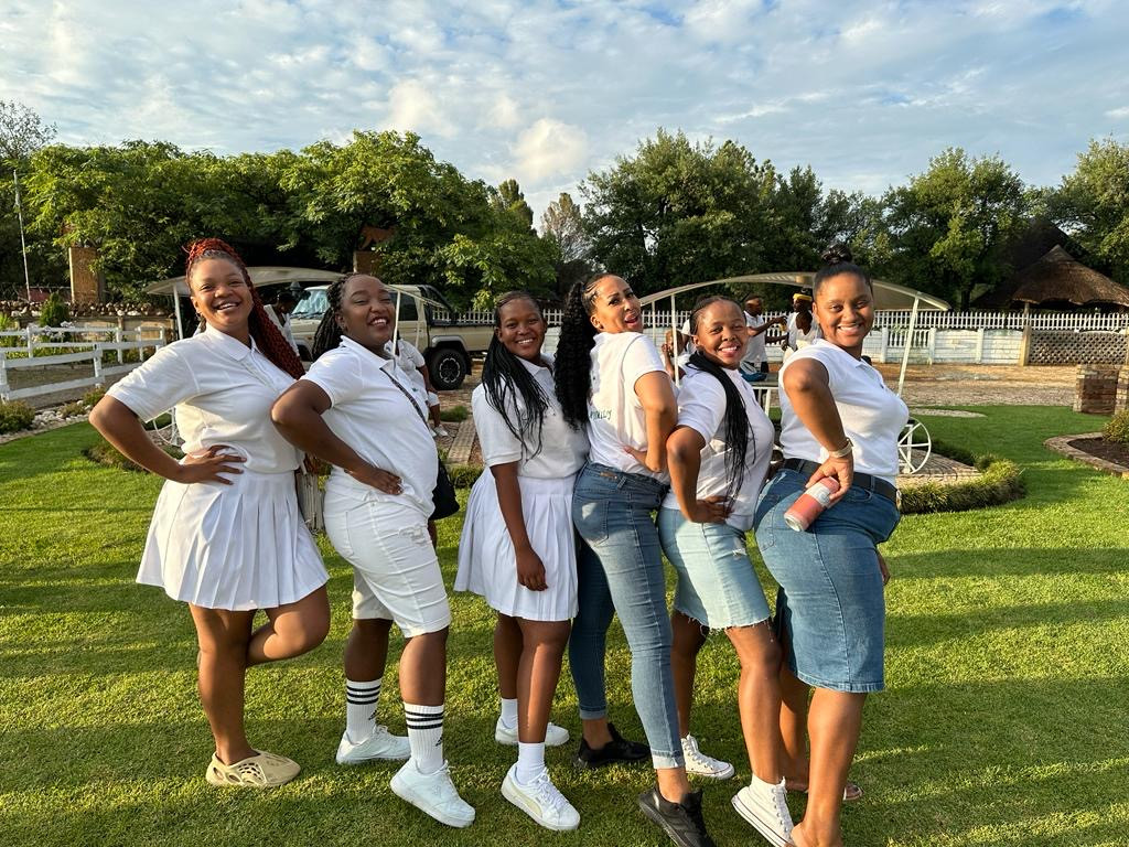 Group of guests posing on the lawn at a social gathering