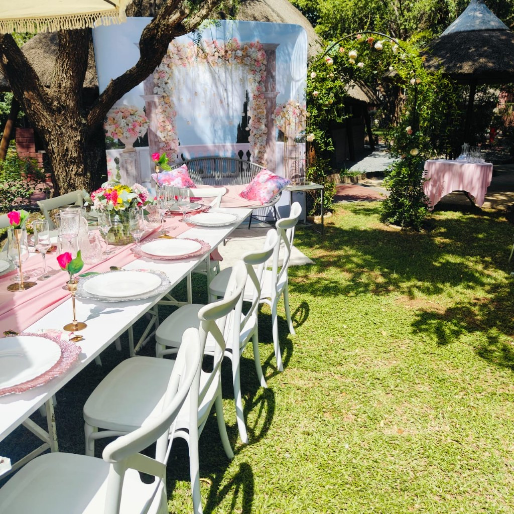 Elegant outdoor table setting with floral centrepieces on the lawn